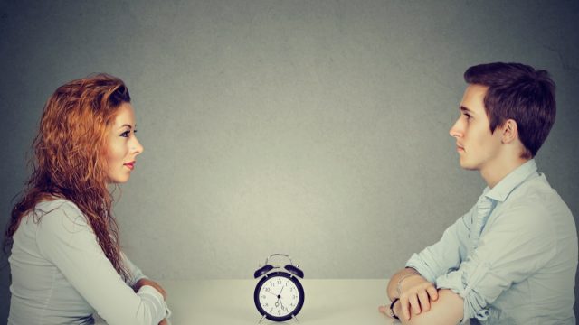man and woman sitting across from one another asking the 36 questions that lead to love