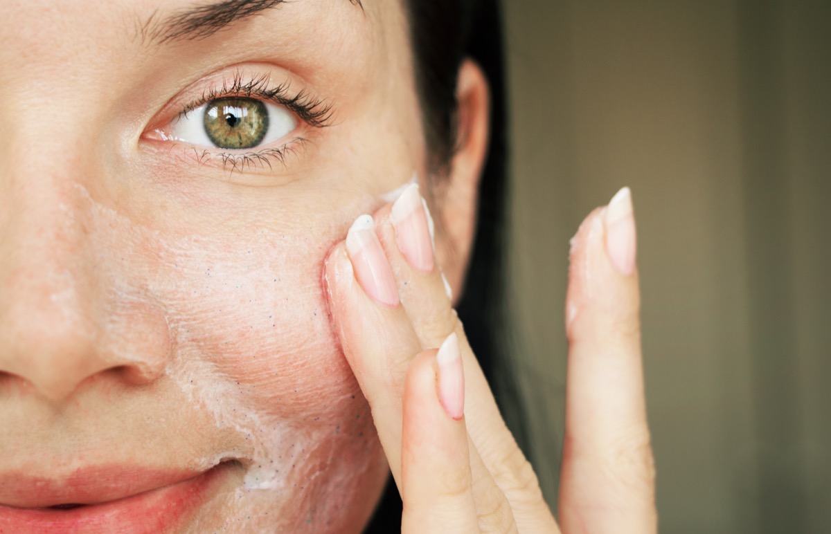 Woman applying skin exfoliant Closeup of woman applying gommage exfoliant
