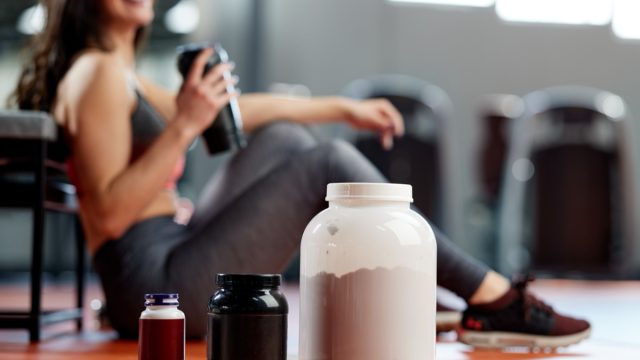 Young woman taking a workout break to enjoy a protein smoothie
