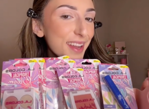Young woman holding up makeup products from Dollar Tree