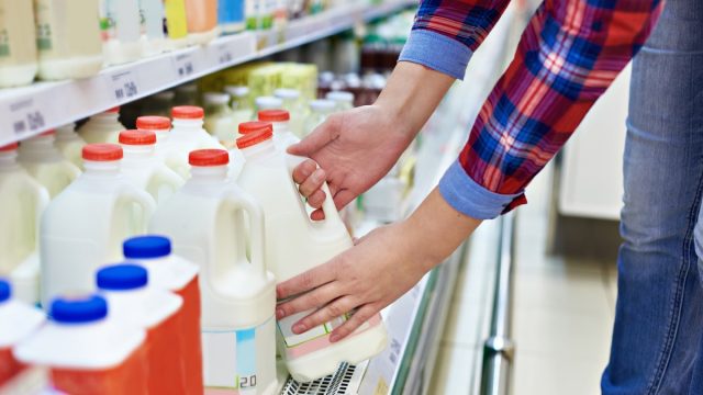 Woman shopping milk in grocery store