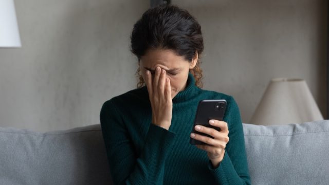 woman stressed out holding her phone