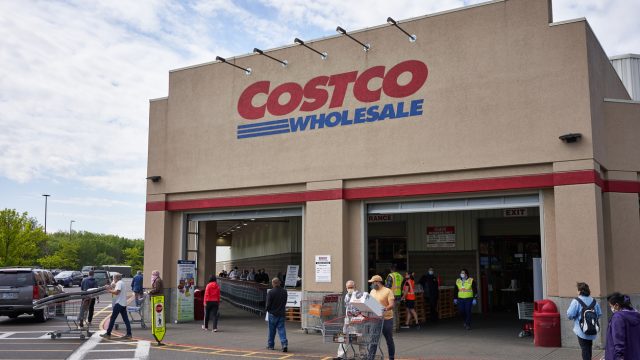A Costco storefront with shoppers entering an exiting
