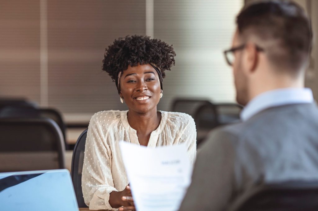 female employee smiling at male interviewer during a job interview.