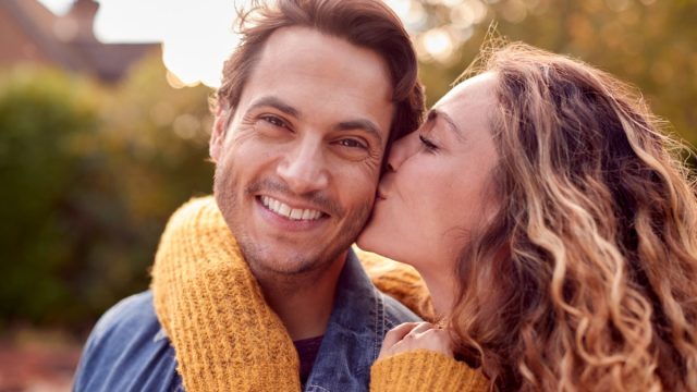 woman kissing man on the cheek
