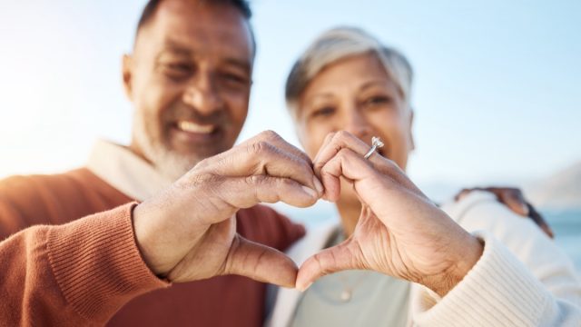 senior couple making a heart with their hands
