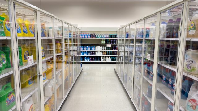 Locked laundry detergent behind glass doors inside a Target store.