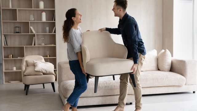 couple moving chairs into their new home