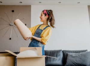 A woman looking at a vase that just arrived in a shipping box