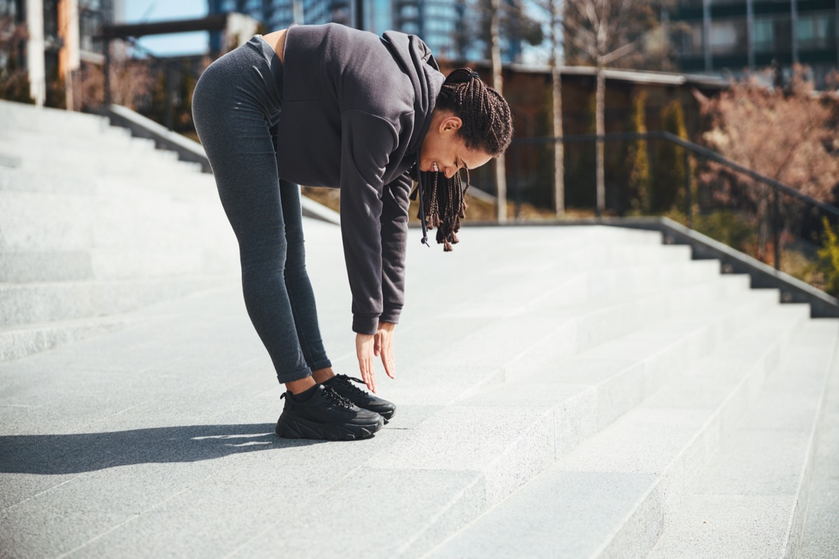 Woman touching her toes to stretch before a run