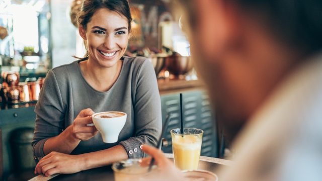 Adorable young couple drinking coffee together in city cafe.