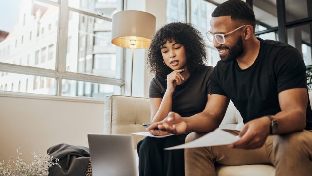 A young couple using a laptop to go over their finances