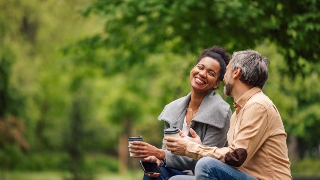 Relaxed adult couple, chatting, while enjoying their coffee.