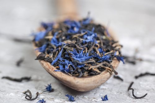 Loose Earl Grey tea leaves on a vintage wooden spoon