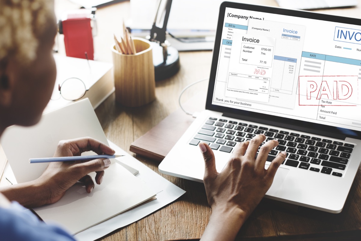 woman looking at a paid invoice on her laptop