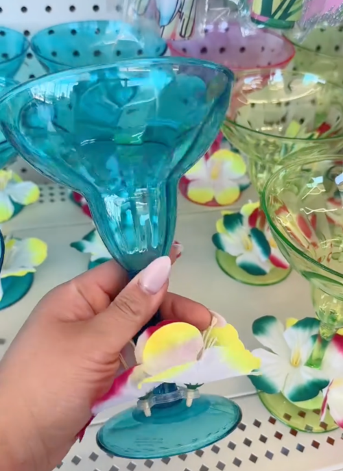 Shopper holding plastic margarita cups in Dollar Tree