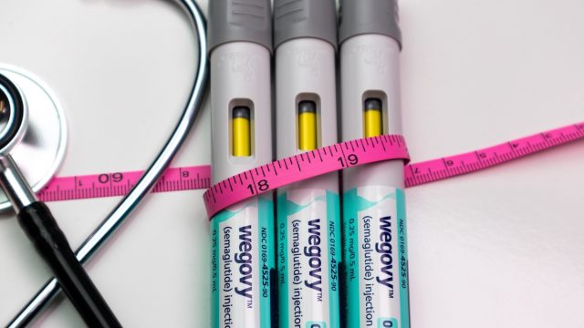 Wegovy auto injector pens with pink tape measure and stethoscope