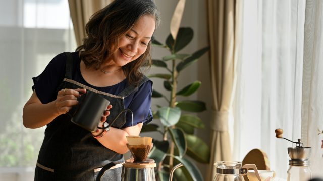A woman making pour over coffee in her kitchen