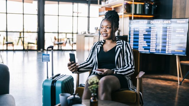 A woman taking a video call on her phone in an airport lounge