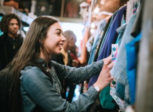 A woman looking through the racks at a thrift store