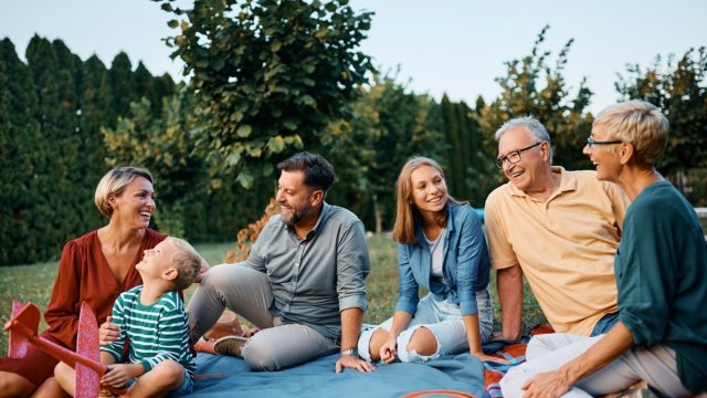 Happy extended family enjoying in conversation while relaxing in their backyard