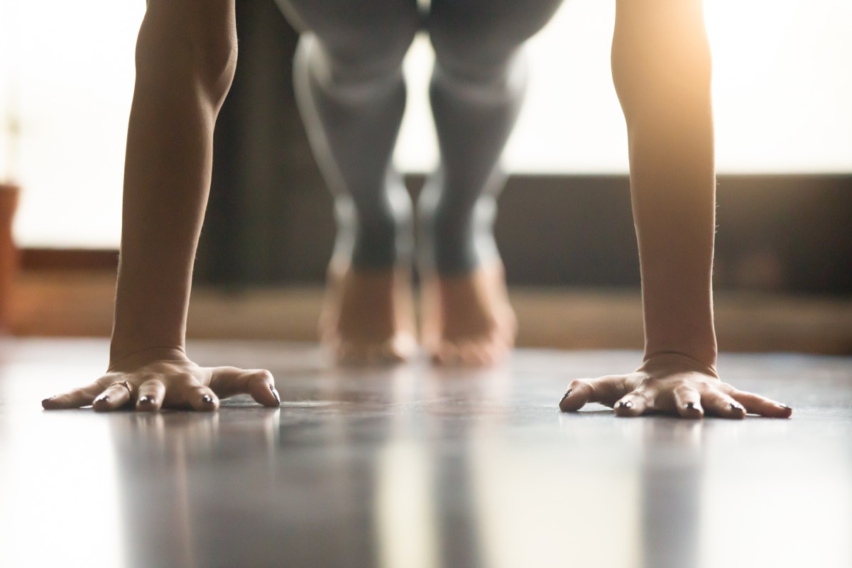 Young woman practicing yoga, doing Push ups or press ups exercise,