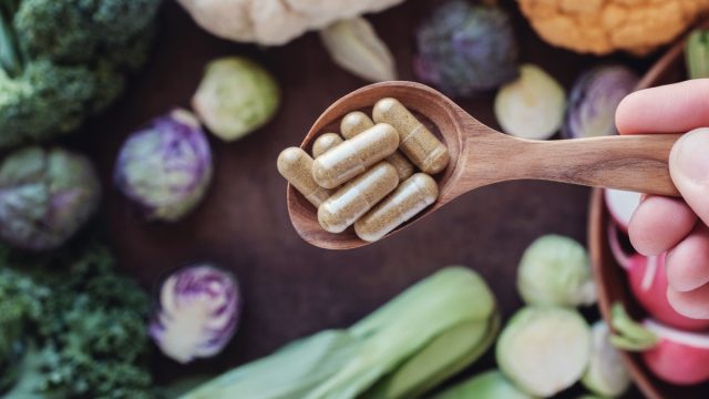 Supplements surrounded by gut healthy vegetables