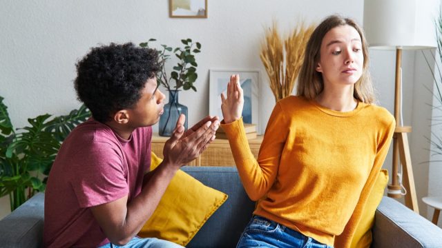man begging for forgiveness and woman turning him down in a house