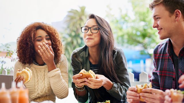 A group of friends eating lunch and laughing