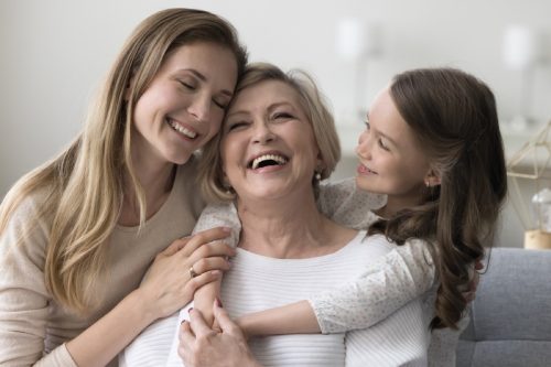 grandmother mother and daughter laughing on the couch