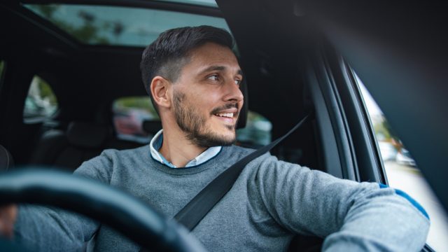 A man driving a car and smiling