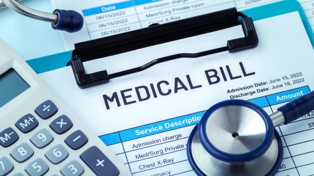 medical bill with stethoscope and calculator