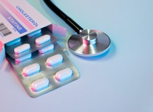 box of statin pills to control cholesterol levels next to a stethoscope