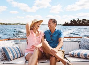Laughing, happy couple and on a boat for retirement travel, summer freedom and holiday in Bali. Smile, love and a senior man and woman on a yacht for vacation adventure, luxury and a cruise date