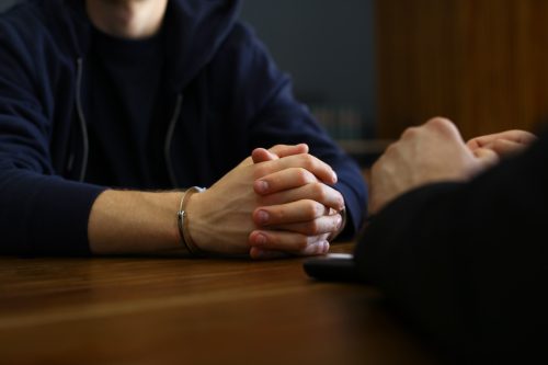 handcuffed person being interrogated
