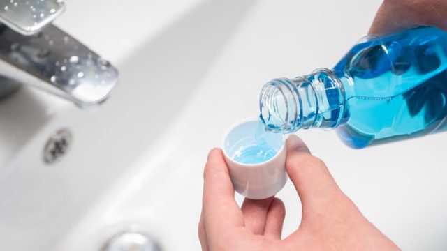 pouring mouthwash over sink
