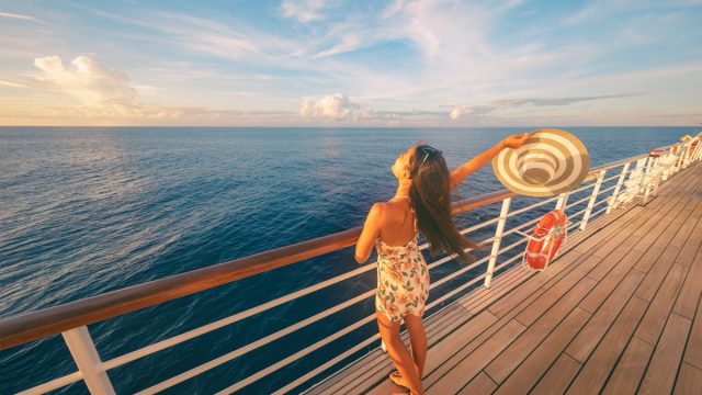 happy single woman on the deck of a cruise ship