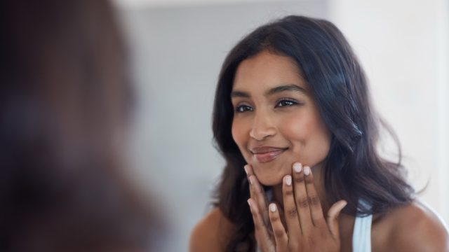 woman looking at herself in the mirror