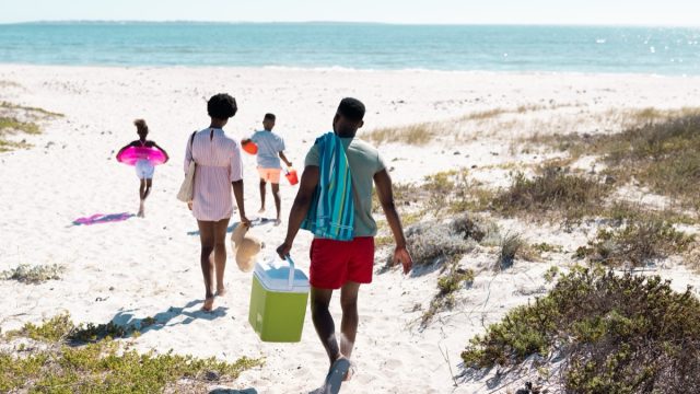 family walking on to the beach