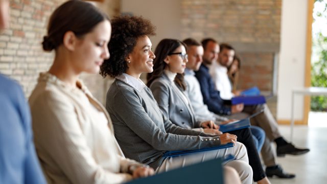 A group of people waiting in an office for a job interview