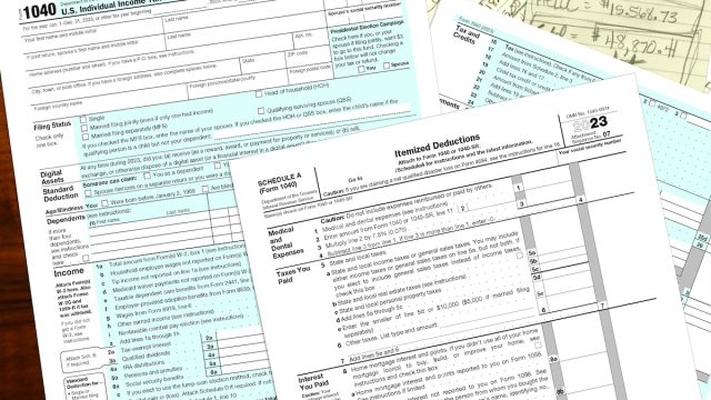 2023 IRS tax forms and hand written notes on a desktop.