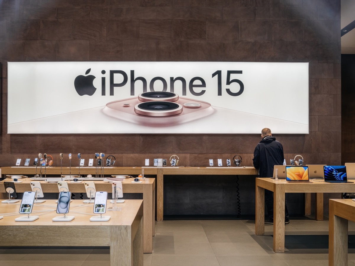 Person in Apple store shopping for iPhone 15