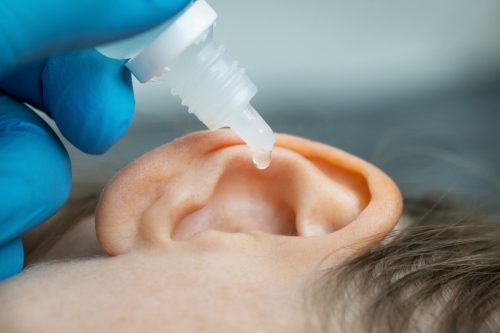 putting ear drops in patient's ear