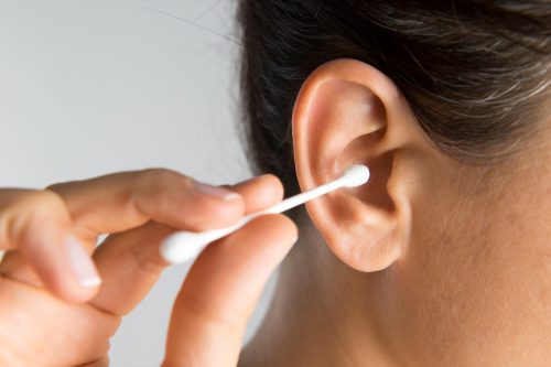woman about to put cotton swab in her ear