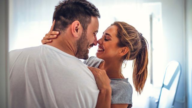 young man and woman embracing, moving into the bedroom