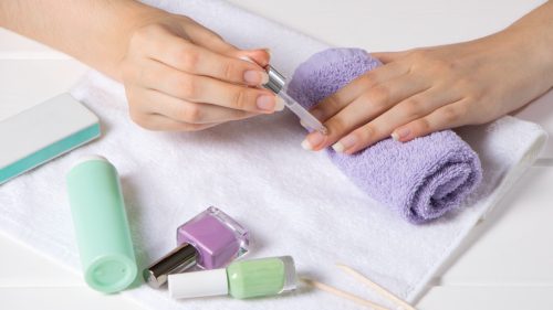 woman applying cuticle oil to nails