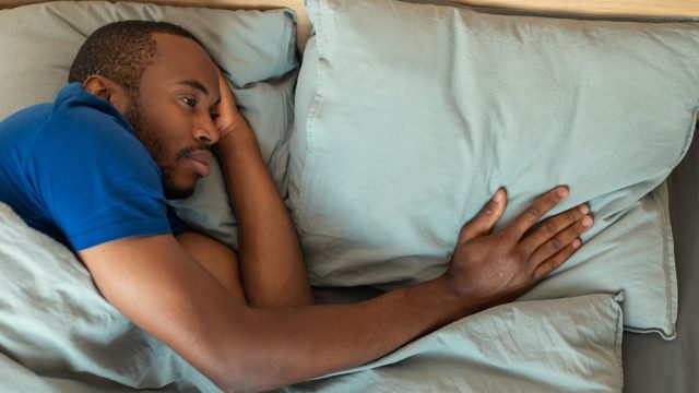 Sad lonely man in bed after breakup