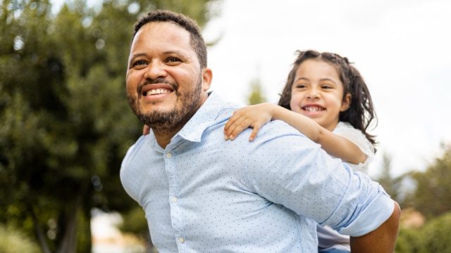 father giving daughter a piggy-back ride