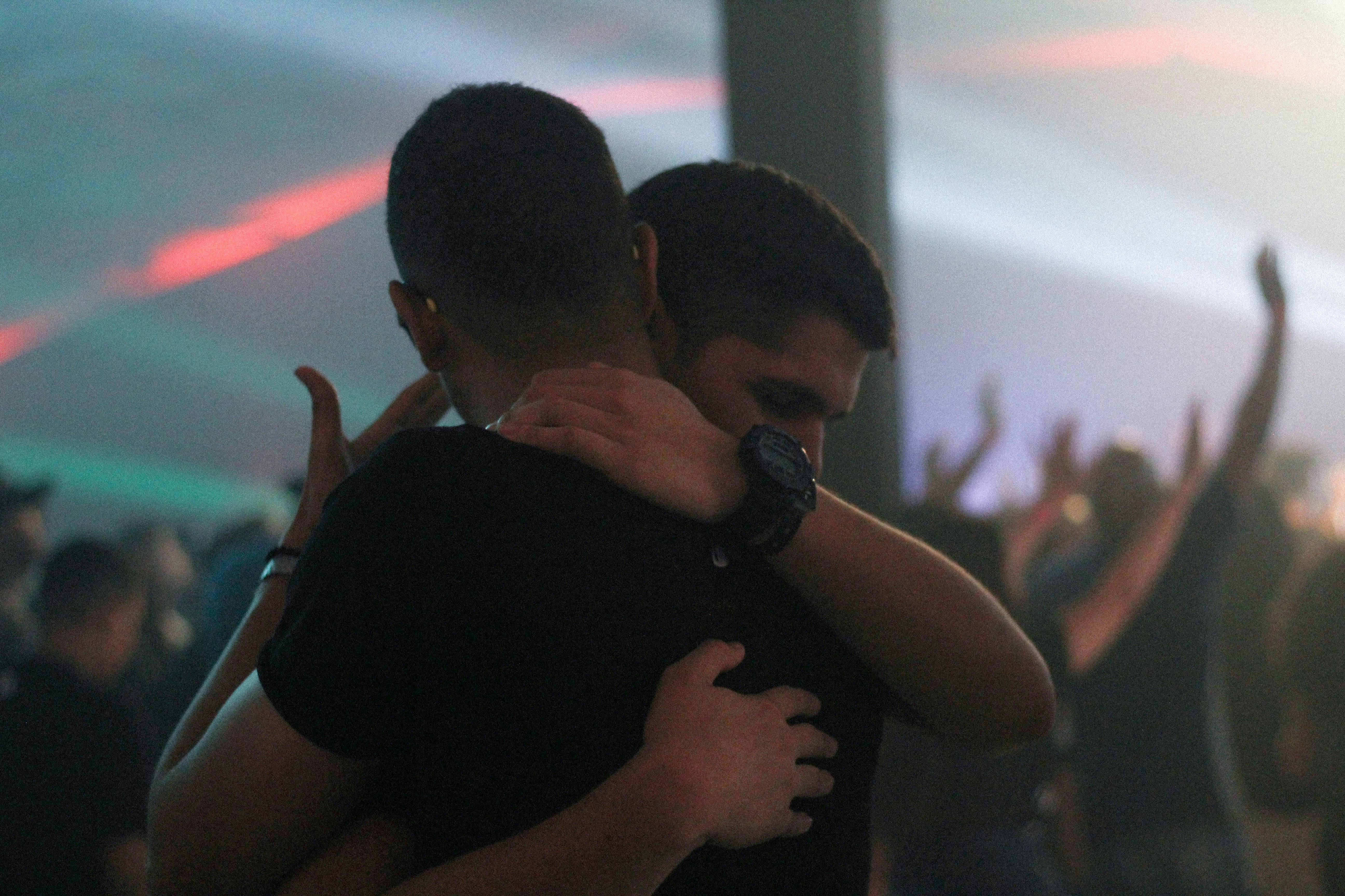a pair of gay men hug each other