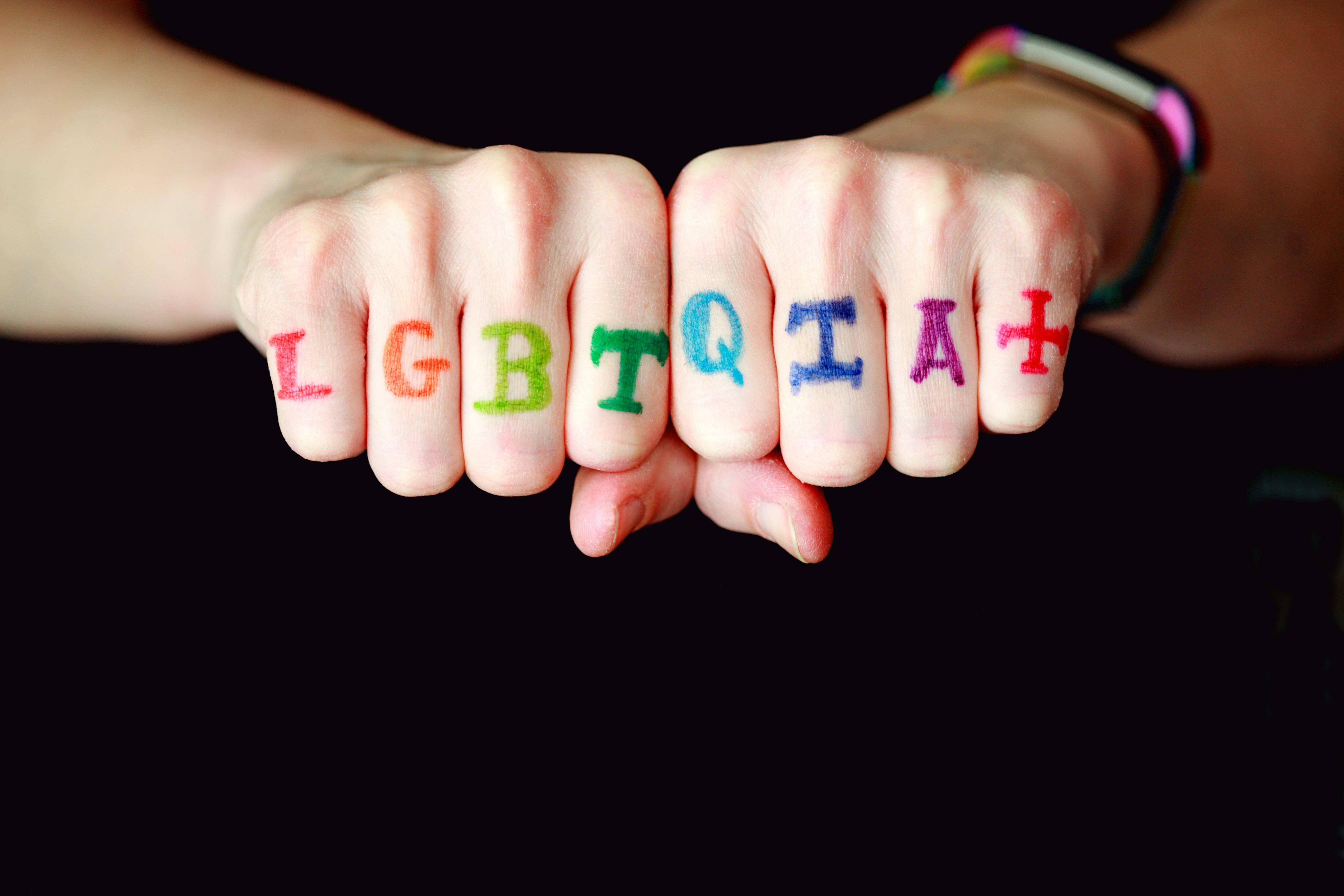 the + acronym on fingers for LGBTQIA+